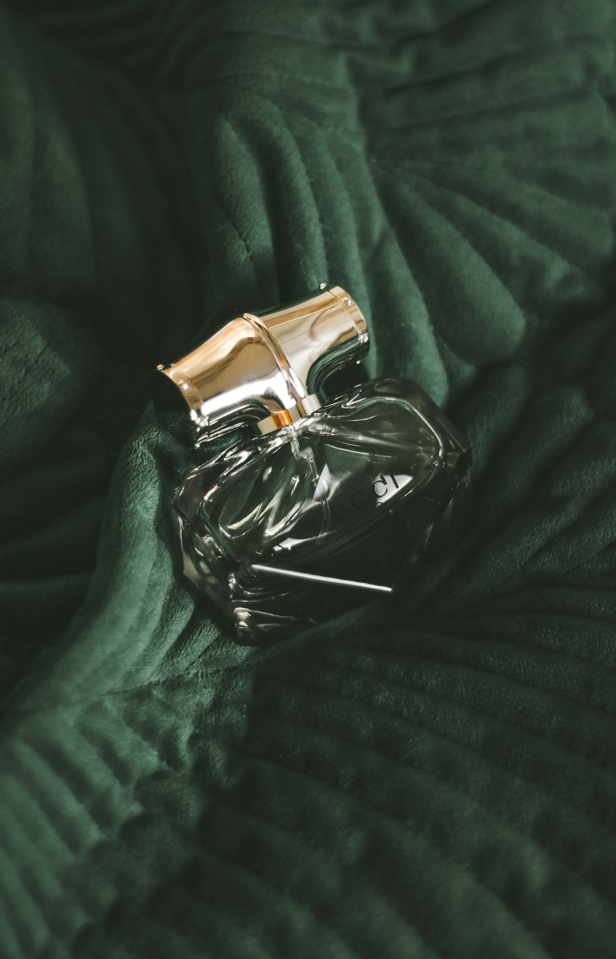 Green perfume bottle in a botanical setting